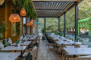 a restaurant with tables and chairs and large windows at Novos Luxury Suites in Bucharest