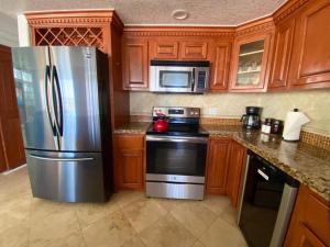 a kitchen with a stainless steel refrigerator and microwave at Rosarito Beach and pool access apartment 2bd 2b in Popotla +26 photos
