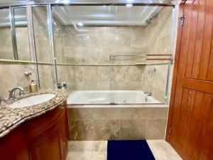a bathroom with a tub and a sink at Rosarito Beach and pool access apartment 2bd 2b in Popotla