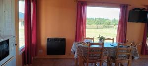 a dining room with a table and chairs and a window at Cabaña Las Lavandas in Trevelín