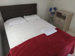 Un dormitorio con una cama con una manta roja. en 301 Apartamento Charmoso, en Vitória da Conquista 7 fotos más