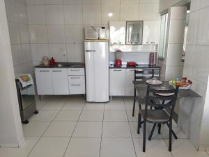Una cocina con refrigerador y una mesa y sillas. en 301 Apartamento Charmoso, en Vitória da Conquista