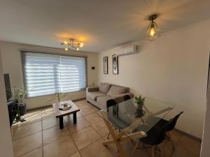 a living room with a couch and a glass table at Casa en Villa Galilea Curicó in Curicó