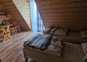 a bedroom with two beds in a log cabin at U Bobaków in Murzasichle