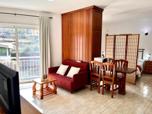 a living room with a red couch and a table at Apartamentos Edalmar in Frontera