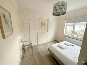 Un dormitorio con una cama y una silla y una ventana. en Limehouse Apartment, en Londres 2 fotos más
