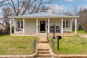 una pequeña casa amarilla con un buzón en el patio en Fraulein Haus walk to Main St sleeps 5, en Fredericksburg