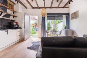 a living room with a couch and a kitchen at Le Palmier Studio - Private Studio in Maisons-Alfort