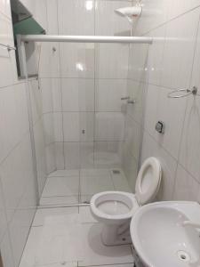 a white bathroom with a shower and a toilet at Apartmento 304 Charmoso no Centro de Conquista in Vitória da Conquista