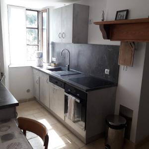 a kitchen with a sink and a stove top oven at Gite de l'Entressac in Pradelles