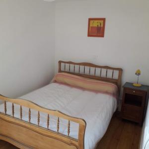 a bedroom with a wooden bed and a side table at Gite de l'Entressac in Pradelles