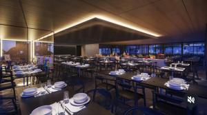 a dining room with tables and chairs with white plates at Flat Recanto Muro Alto - Porto de Galinhas in Ipojuca