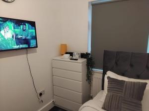 a bedroom with a bed and a tv on the wall at Luxurious space in Erith +11 photos