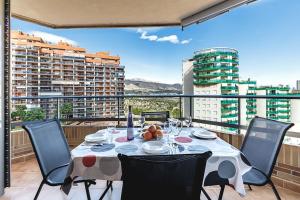 a table on a balcony with a view of buildings at Apartamento en Villajoyosa Benidorm con Gimnasio y Spa in Villajoyosa