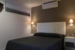 sypialnia z łóżkiem i 2 szafkami nocnymi w obiekcie Hostal Sant Pau w Barcelonie