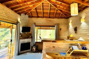 a living room with a fireplace and a tv at Chalé Recanto da Mantiqueira in Gonçalves