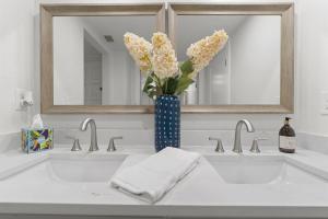 a bathroom sink with a blue vase with flowers in it at Perfect Getaway Ponte Vedra Beach Lifestyle in Ponte Vedra