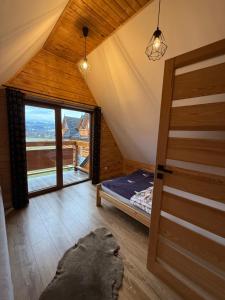 a attic room with a bed and a large window at Domki na Stoku in Czarna Góra