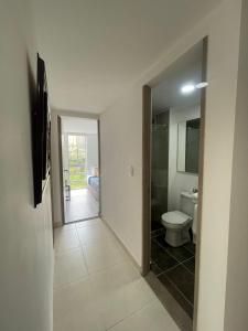 a hallway of a bathroom with a toilet and a mirror at Muy Cerca al CC Fundadores, U Autonoma & El Centro in Manizales