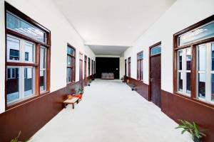 Un pasillo vacío de un edificio con ventanas. en SPOT ON Hotel Lakshya Ghatampur, en Kānpur