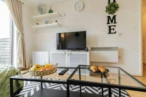 a living room with a glass coffee table and a television at Central 2Bed,2Bath, Balcony Apartment Near New Street, Mailbox & Canals at Skyline Apartments in Birmingham