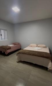 a bedroom with two beds in a room at Hotel Helena Palace in Bonfinópolis