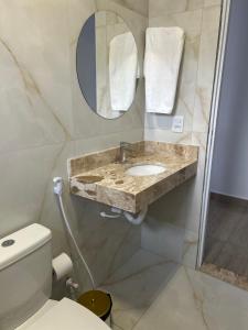 a bathroom with a sink and a toilet at Hotel Helena Palace in Bonfinópolis