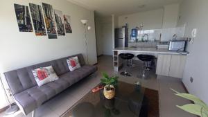 a living room with a couch and a kitchen at Departamento Hermosa Vista Cercano Playa Herradura in Coquimbo