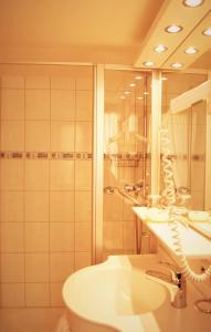 a bathroom with a sink and a toilet and a mirror at Hotel Gasthof Kreuz in Bad Buchau