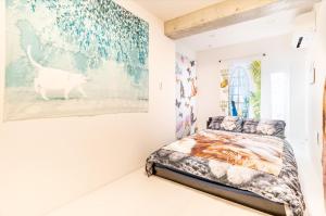 a bedroom with a bed and a painting on the wall at TOKYO SKYTREE Cat house 押上駅徒歩6分 浅草 in Tokyo