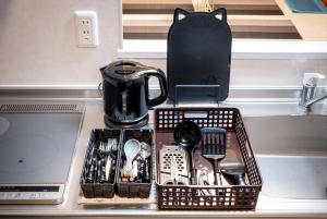 a tray of utensils on a counter next to a laptop at TOKYO SKYTREE Cat house 押上駅徒歩6分 浅草 in Tokyo +45 photos