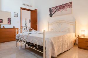 Un dormitorio con una gran cama blanca y una cómoda. en Dimora Teresa, en San Pietro Vernotico