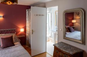 a bedroom with a mirror and a bed and a couch at Le Rockastel in Le Caylar
