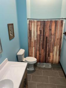 a bathroom with a toilet and a wooden shower curtain at School House Inn, 10 Bed, 4 Bath, Sleeps 18, Game Room, Jetted Tub in Eau Galle