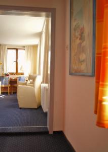 a living room with a white couch and a table at Hotel Gasthof Kreuz in Bad Buchau