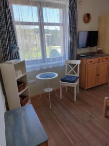 salon ze stołem, telewizorem i oknami w obiekcie Wellness Chata Rosnatka w mieście Kvilda
