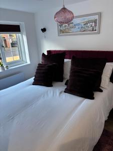 a large white bed with black pillows in a bedroom at Loom Lodge in Great Wyrley