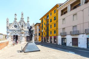 a statue in the middle of a street with buildings at Orlando's House - Pisa Downtown with View in Pisa