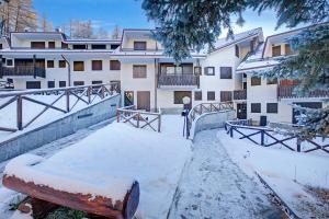 ein Gebäude mit Schnee auf dem Boden davor in der Unterkunft Appartamento Pian dei Larici - Happy Rentals in Sauze dʼOulx