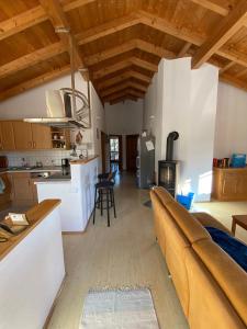 eine Küche und ein Wohnzimmer mit einem Sofa und einem Herd in der Unterkunft Ferienwohnungen Wolfgang Geistanger - inkl. Chiemgaukarte in Siegsdorf