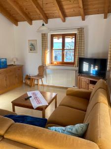 ein Wohnzimmer mit Sofa und Fernseher in der Unterkunft Ferienwohnungen Wolfgang Geistanger - inkl. Chiemgaukarte in Siegsdorf