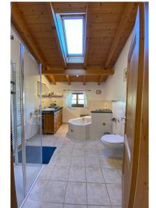 ein Bad mit einem WC, einer Badewanne und einem Fenster in der Unterkunft Ferienwohnungen Wolfgang Geistanger - inkl. Chiemgaukarte in Siegsdorf