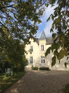 a white house with a bench in front of it at Manoir de Manapany in Angliers