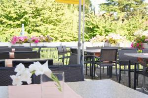 a bunch of tables and chairs with flowers on a patio at Hotel Gasthof Kreuz in Bad Buchau