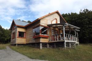 a wooden house sitting on top of a field at karukinka in Chonchi