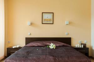 a bedroom with a bed with a flower on it at Хотел Дикас in Smolyan