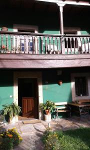 un edificio con balcón, mesa y banco en Casa de Aldea Florentina, en Arenas de Cabrales