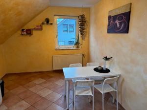 a dining room with a white table and chairs at Pension Platzhirsch 2 in Geisleden