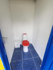 a bathroom with a toilet with a red seat at CASA CAMPESTRE el jardín in Filandia +3 photos