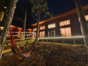a hammock in front of a building at night at Cabañas Bosque marino in Pichilemu